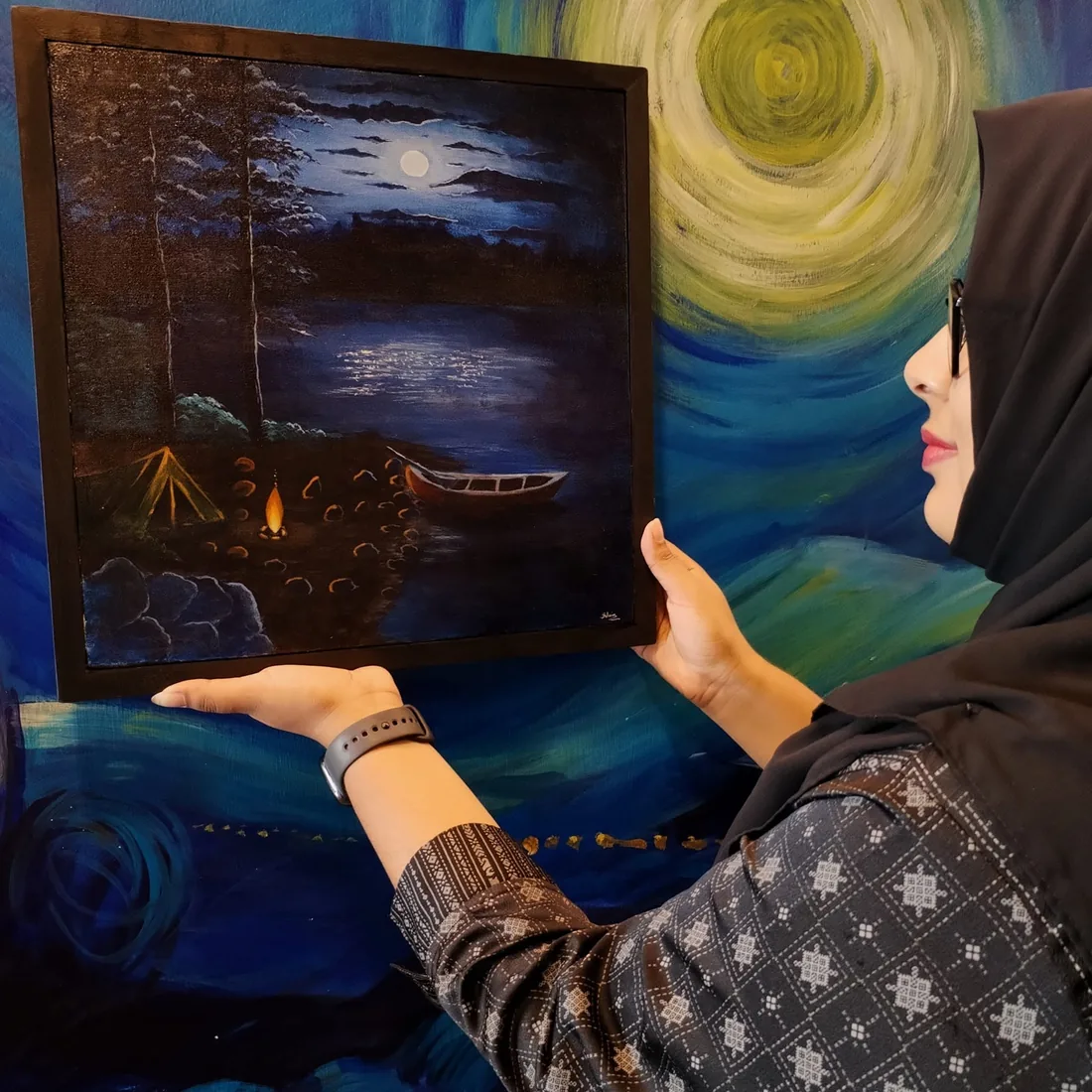 Silvia holding one of her paintings